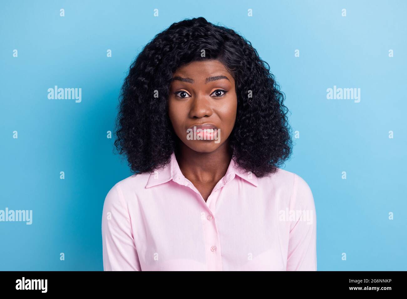 Photo of impressed guilty dark skin lady dressed pink clothes biting lip isolated blue color background Stock Photo