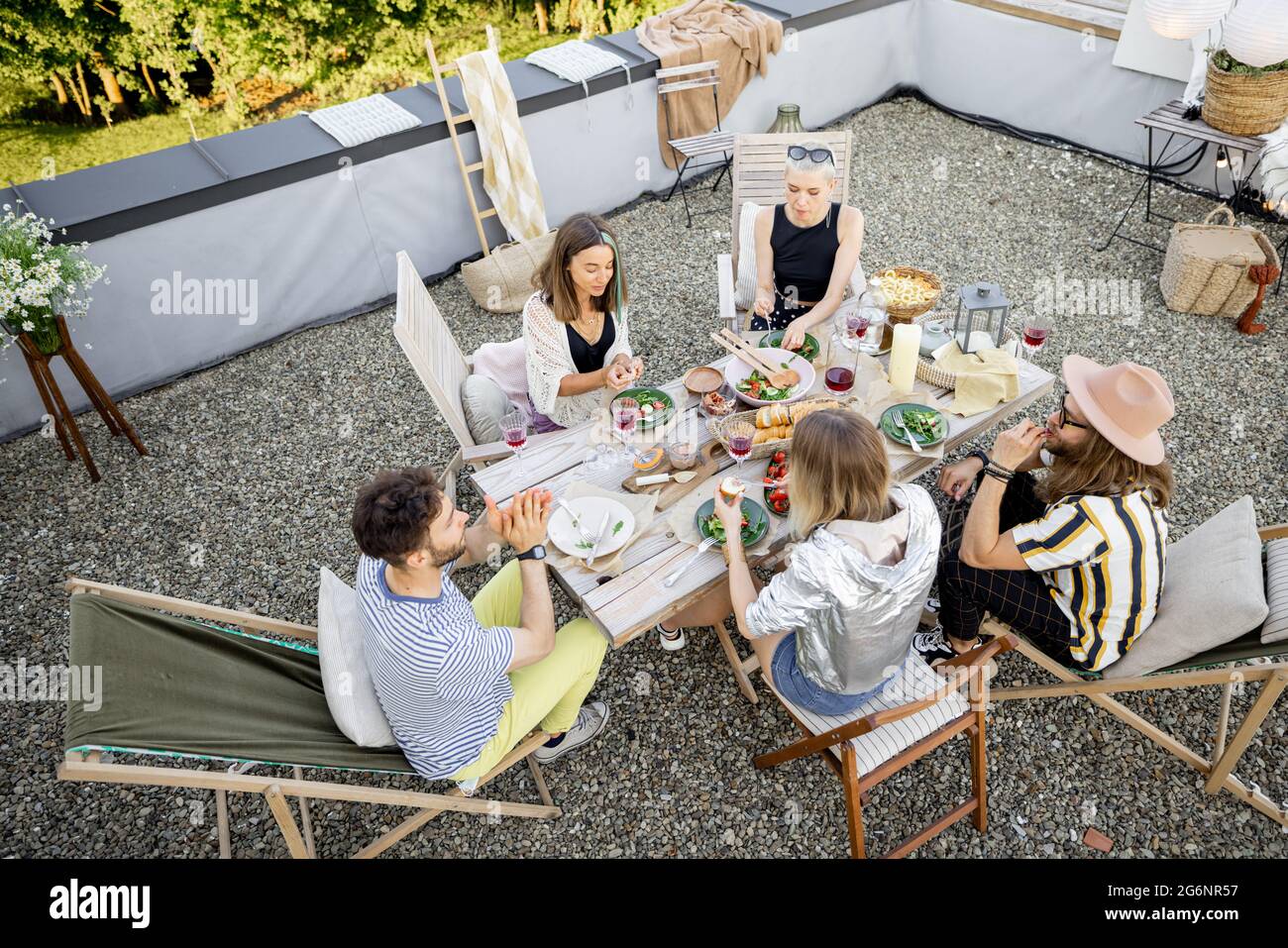 Friends have a estive dinner on a rooftop terrace Stock Photo