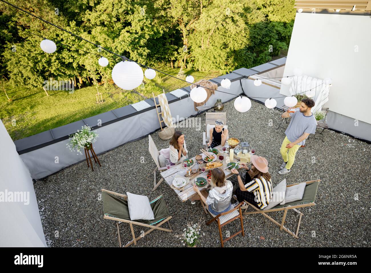 Friends have a estive dinner on a rooftop terrace Stock Photo