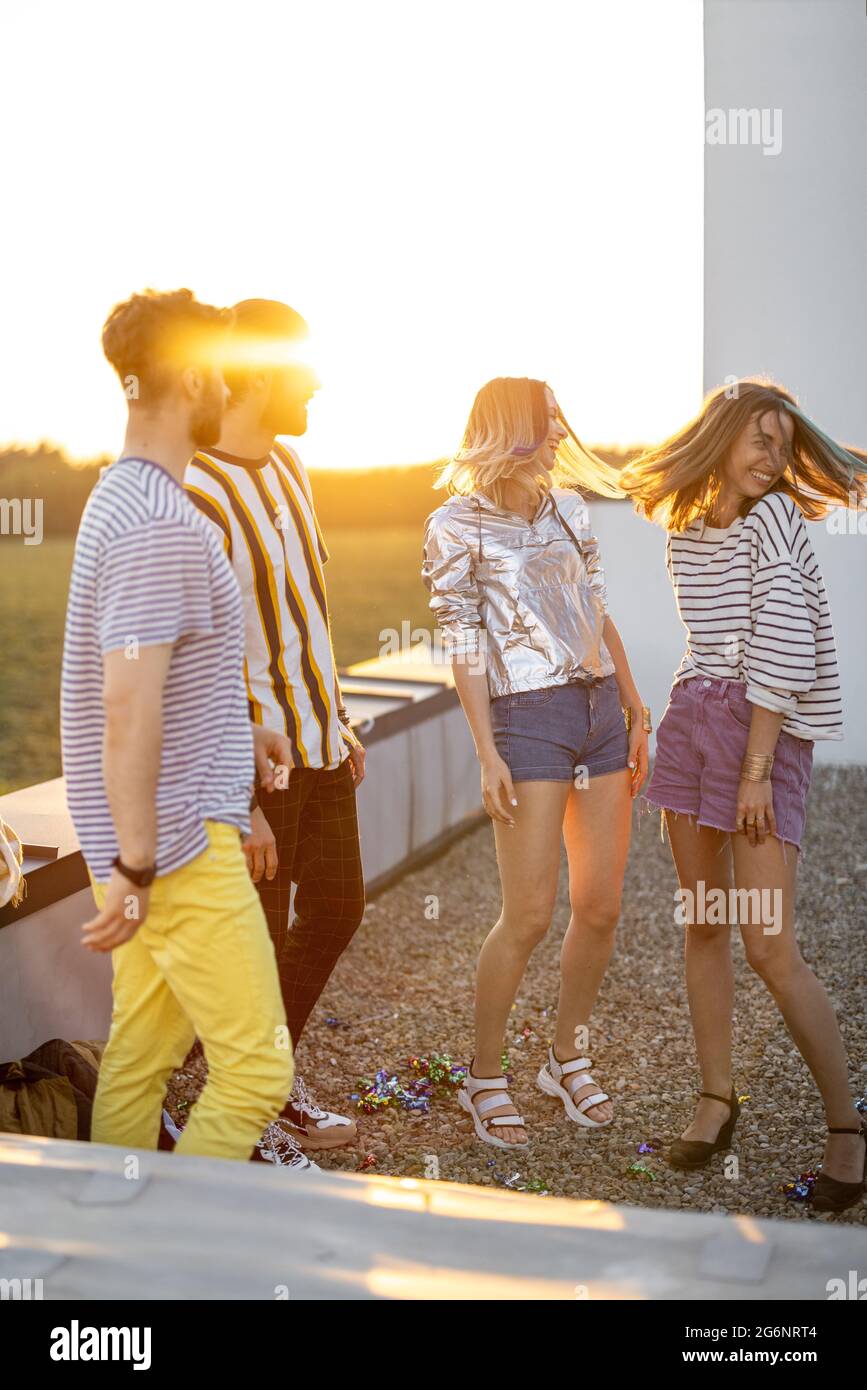 Friends dancing at rooftop terrace on sunset Stock Photo