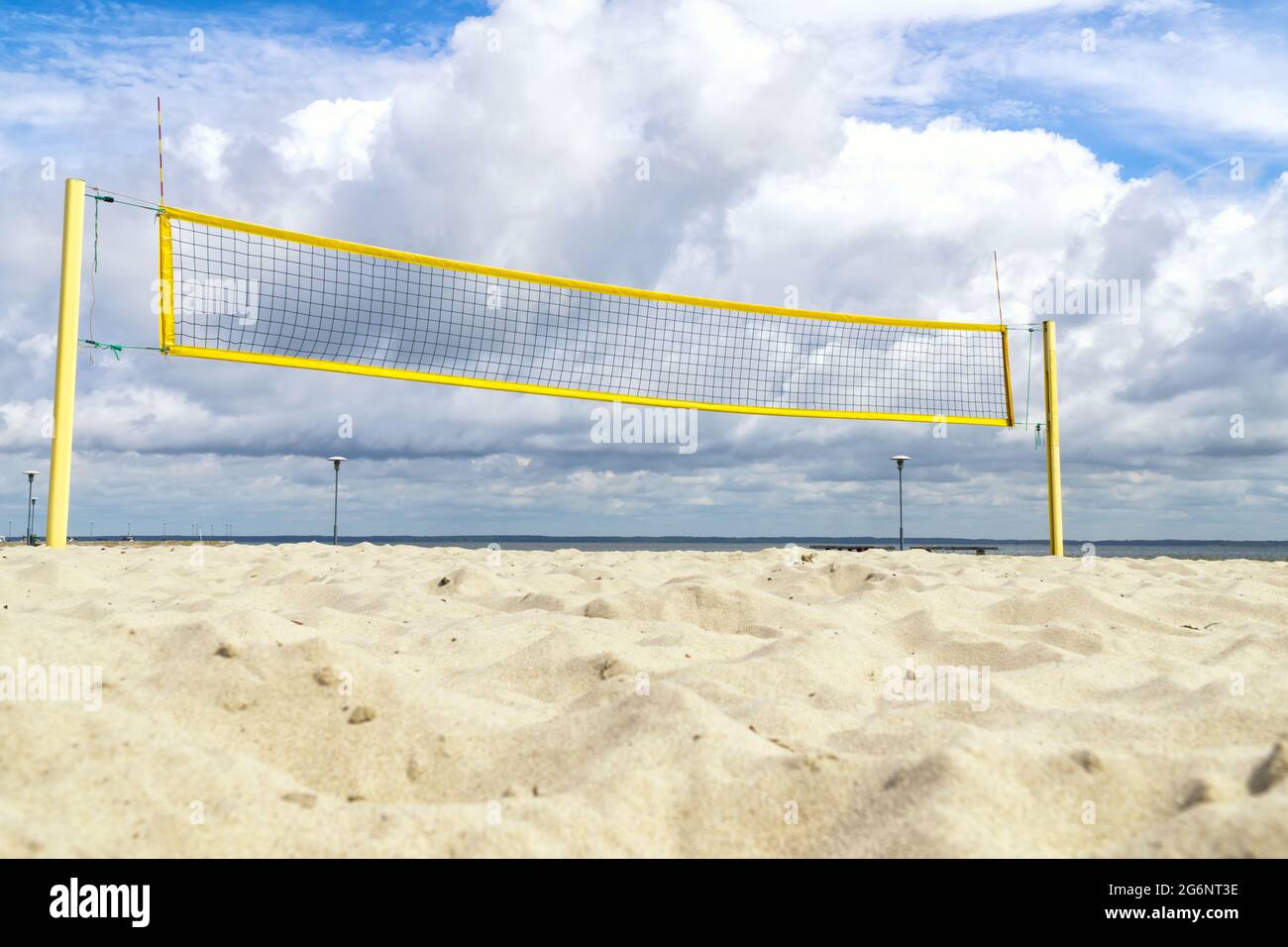 Volleyball net on the seaside beach with white clouds on blue sky Stock Photo