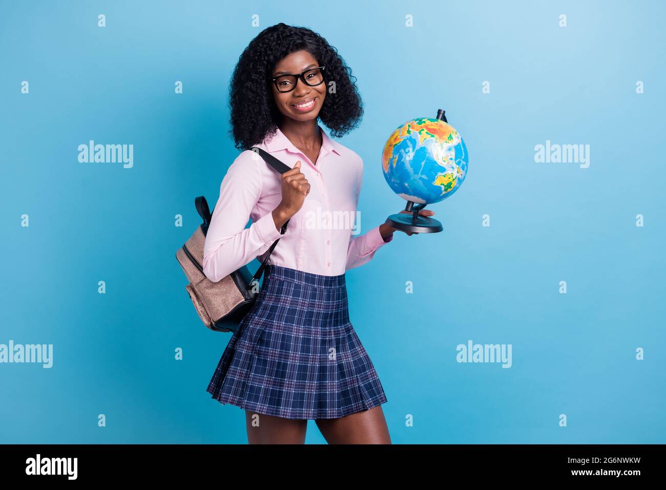 Photo of young cheerful black girl happy smile hold globe geography lesson study homework isolated over blue color background Stock Photo