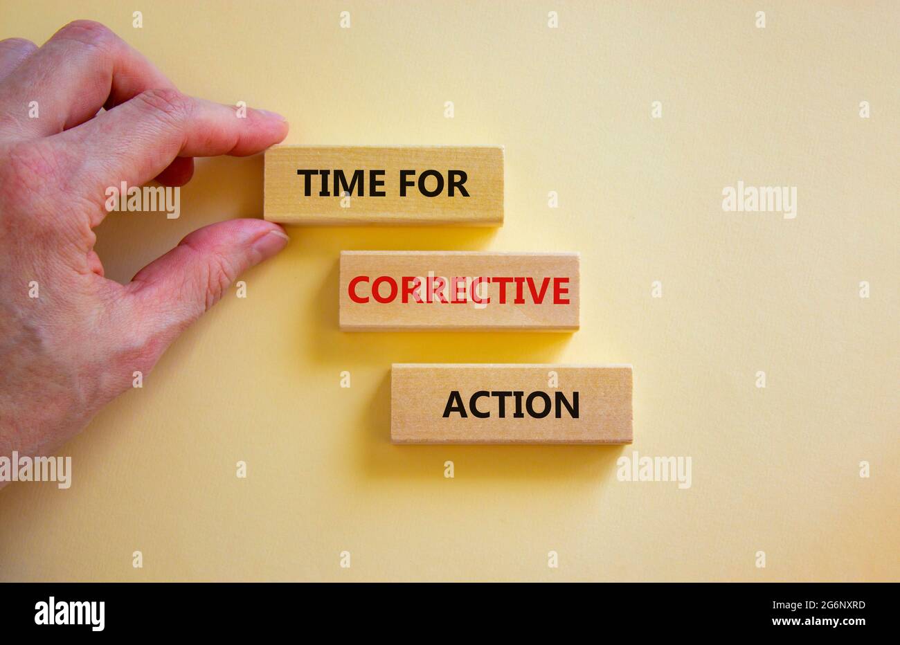 Time for corrective action symbol. Wooden blocks with words 'Time for corrective action' on a beautiful white background. Businessman hand. Business, Stock Photo