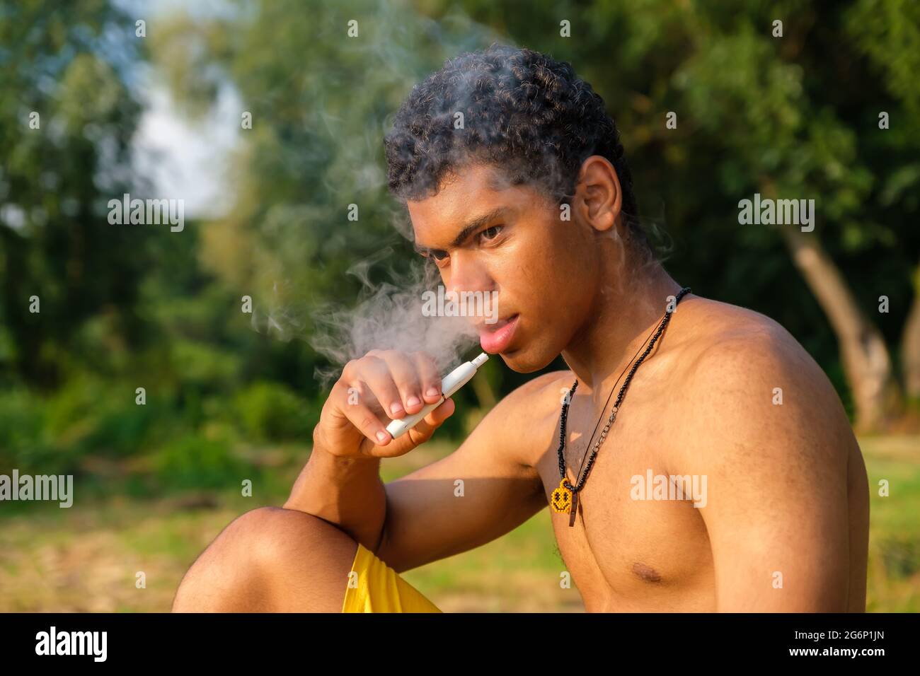 African-American young man vaping e-cigarette with e-liquid Stock Photo -  Alamy