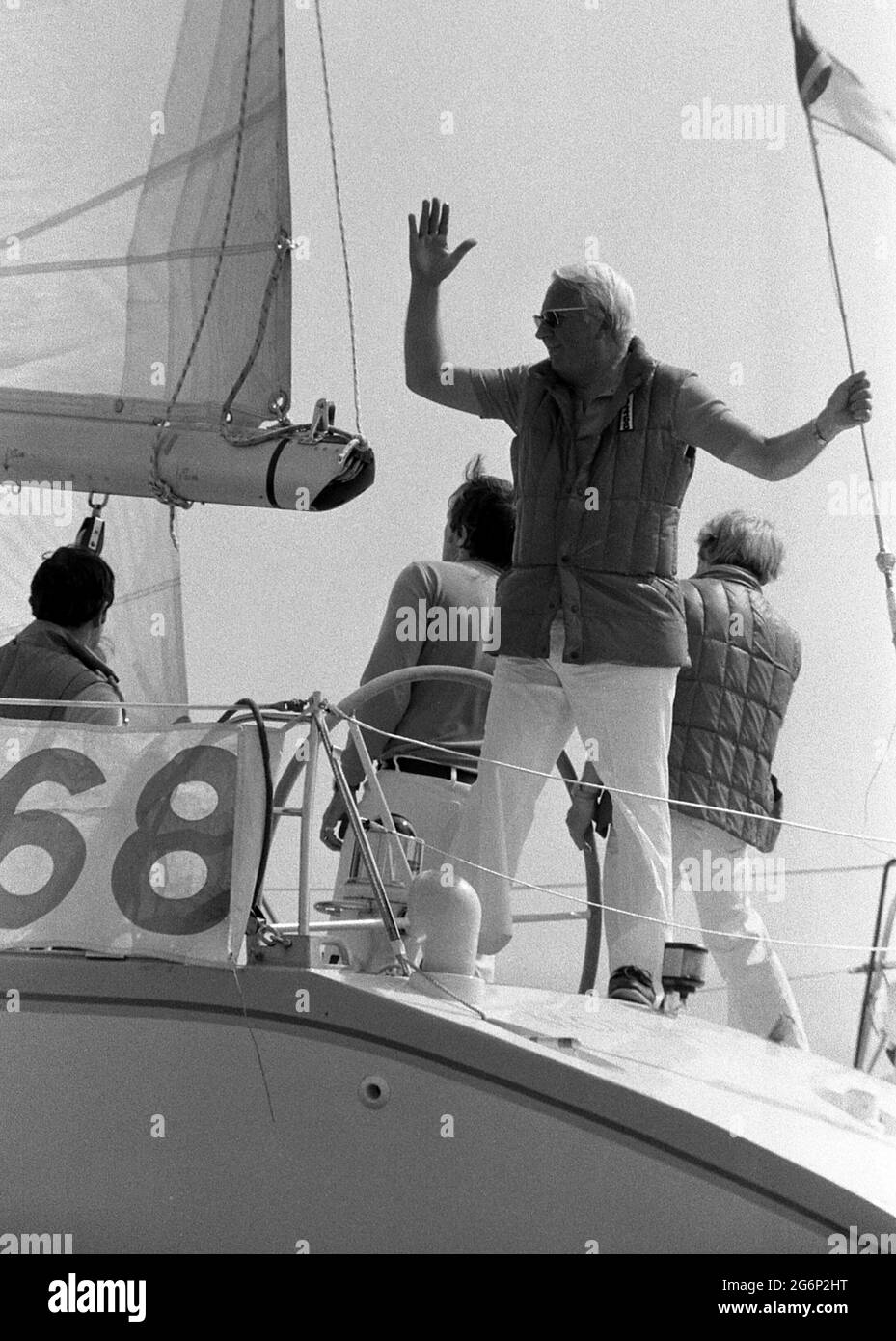 AJAXNETPHOTO. 7TH JULY,1979. SOLENT, COWES, ENGLAND. - KEEPING LOOKOUT - EDWARD HEATH STANDING LOOKOUT IN THE STERNSHEETS OF HIS YACHT MORNING CLOUD AT THE START OF THE COWES - DINARD OFFSHORE RACE WAVING TO SPECTATORS.  PHOTO:JONATHAN EASTLAND/AJAX REF:2790707 18 18 Stock Photo