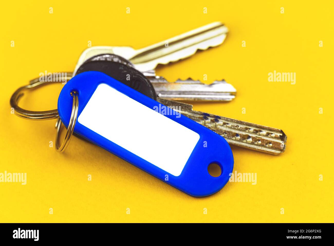 Keys with mockup plastic badge with copy space, concept of new property purchasing, yellow background Stock Photo