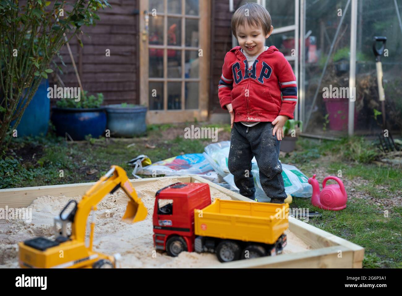 A young boy playing with toys outdoors Stock Photo