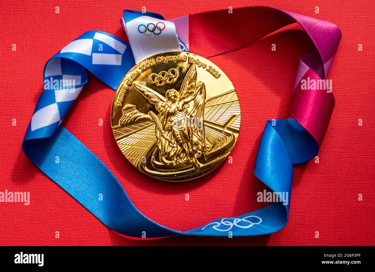 April 25, 2021 Tokyo, Japan. Gold medal of the XXXII Summer Olympic Games  in Tokyo on a red background Stock Photo - Alamy