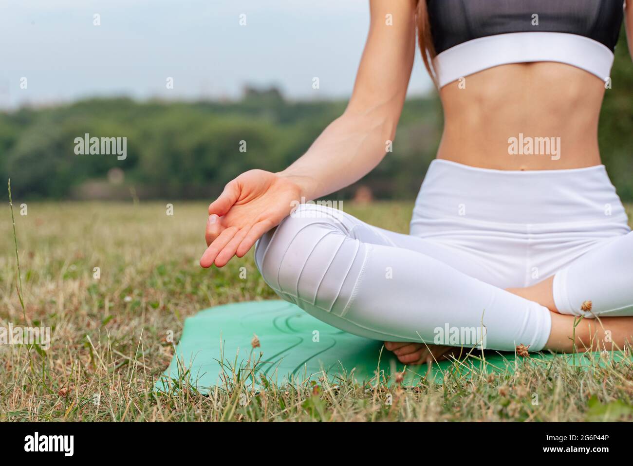 Slim young woman doing yoga in the city park Stock Photo