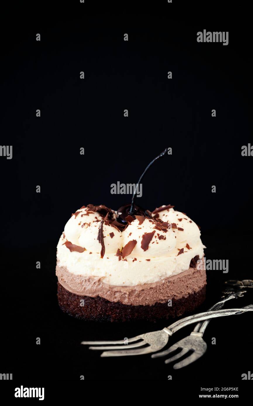 Cream cake with two forks against a black background Stock Photo