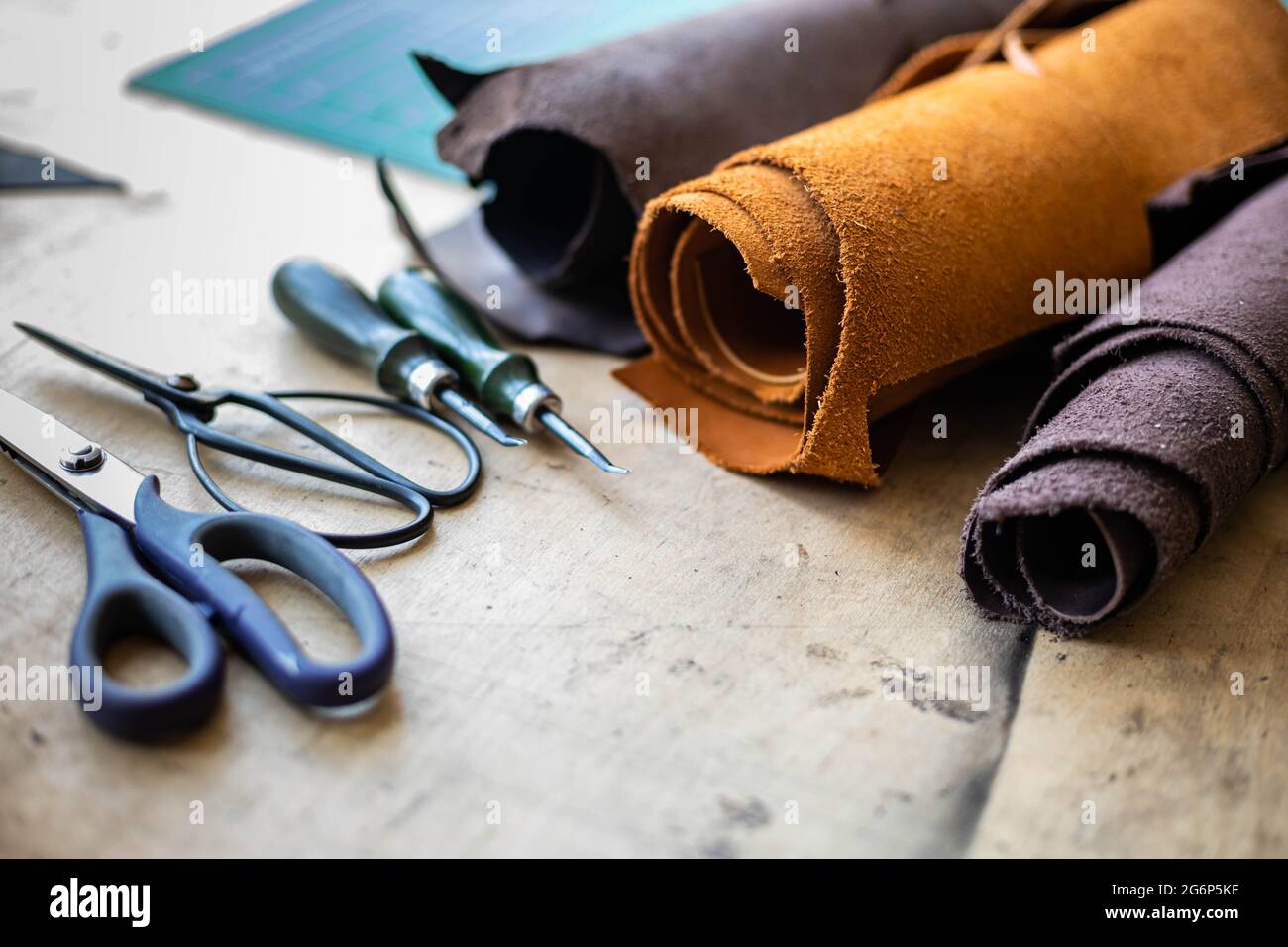 Top view wooden table surface copyspace with materials, instruments. Leather workshop Stock Photo