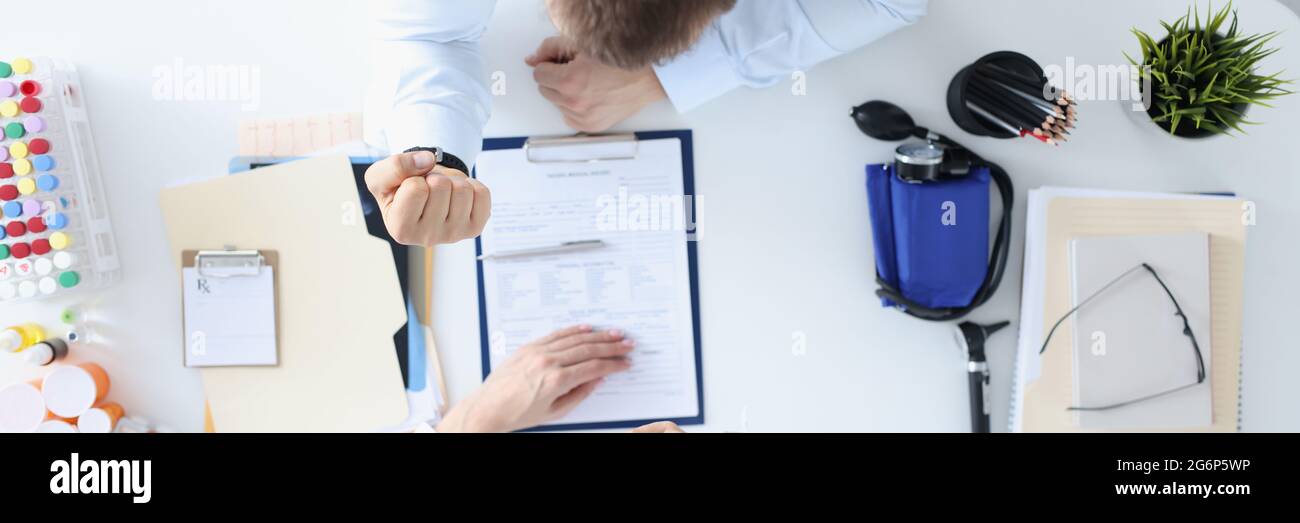 Man showing woman doctor fist in clinic top view Stock Photo