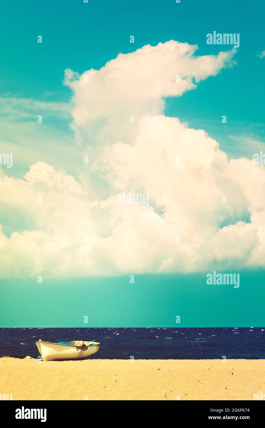 Boat on a beach beneath a big cloud Stock Photo