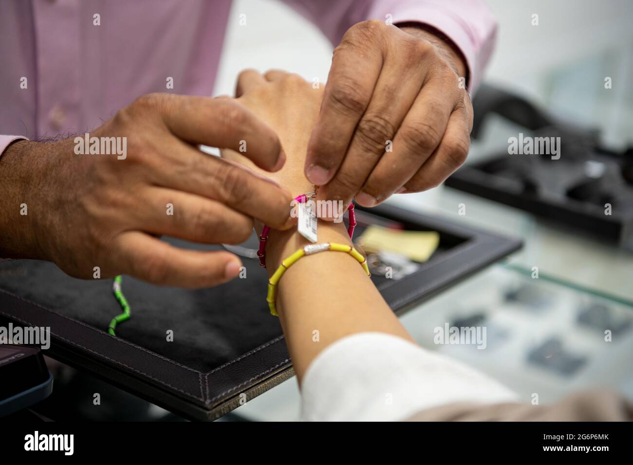 Girl hand trying diamond jewelry at jewelry shop. wearing diamond jewelry Stock Photo