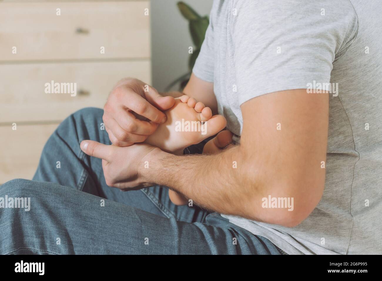 Dad holds and tickles feet of kid. Boy plays with his father. Family having fun at home Stock Photo