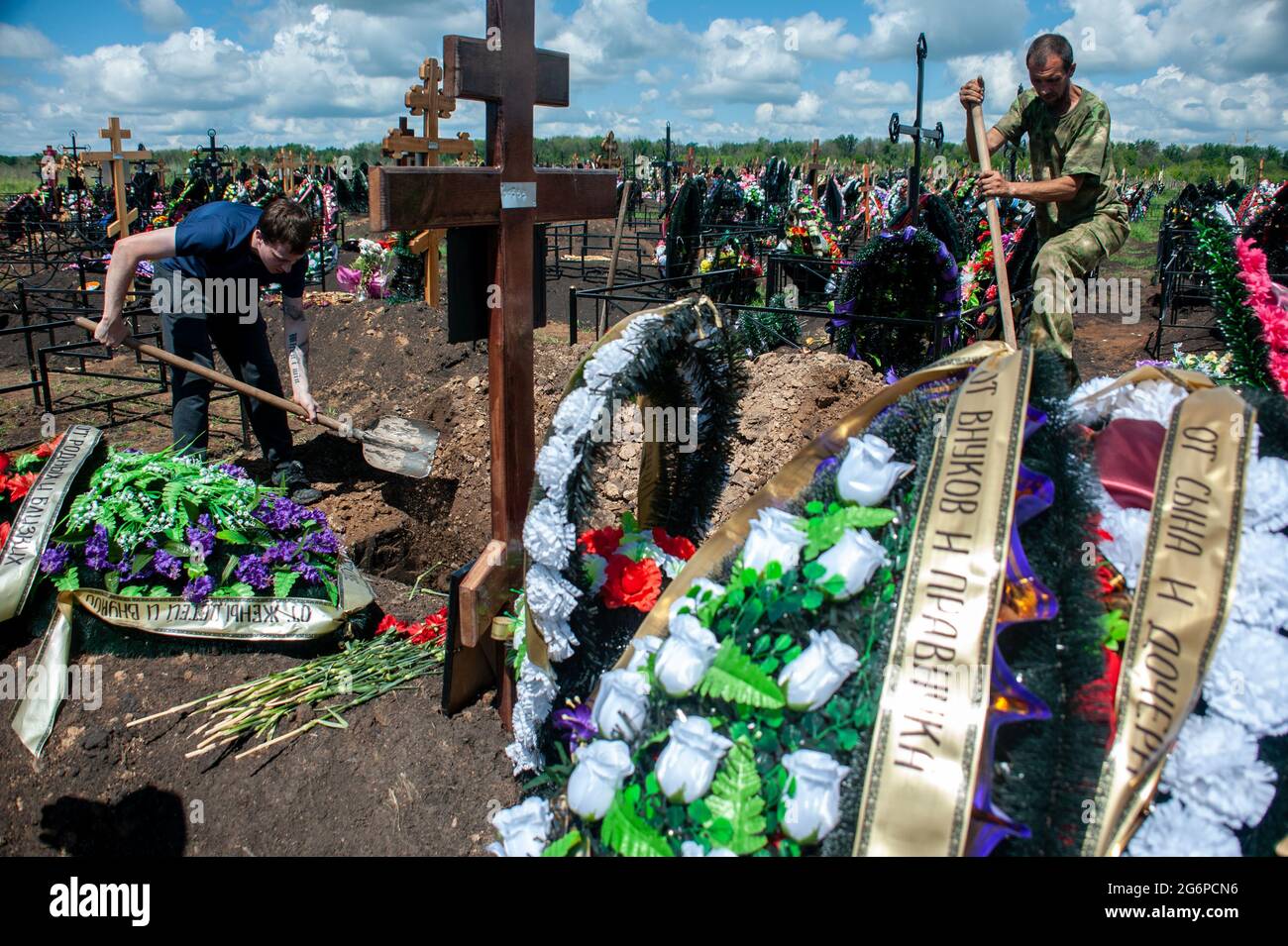 Tambov, Russia. 02nd July, 2021. Gravediggers are seen working on a grave at the Polynkovsky cemetery.Russia has taken the second place in the world in terms of mortality from a new coronavirus infection. In the city of Tambov (Russia), those who have died from coronavirus are buried in closed coffins with a small window through which the face of the deceased can be seen. Credit: SOPA Images Limited/Alamy Live News Stock Photo