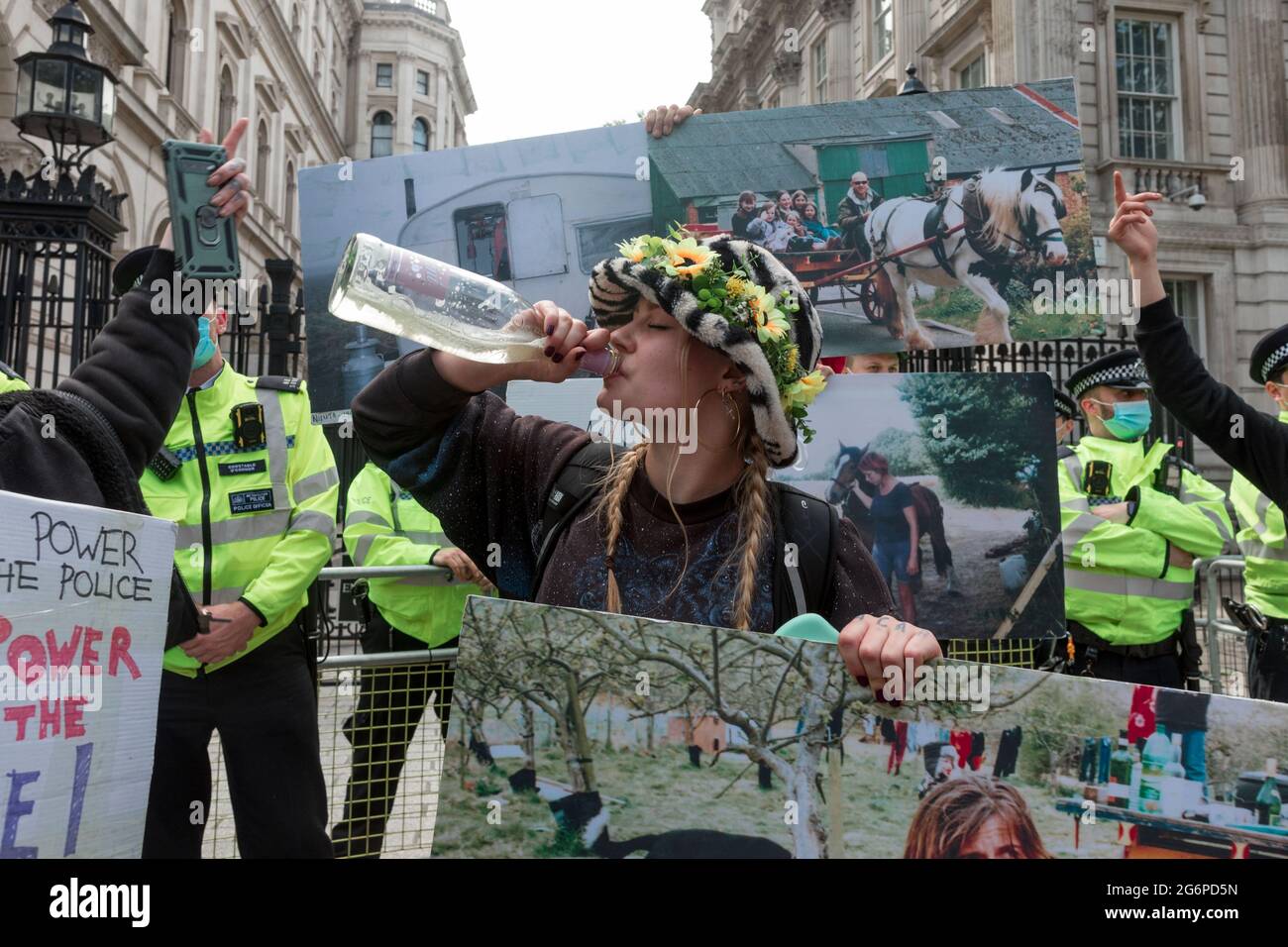 A protestor holding a placard drinks alcohol during the demonstration.Drive2Survive is a grass roots campaign against Section 4 of the Policing Bill that threatens Gypsy, Roma, Irish Travelers and nomadic life in the UK. A protest was held against the policing bill because it threatens the nomadic life in the UK, giving the police power to seize Gypsy, Roma and Irish traveler homes, and subject the community to heavy fines. The rally began at Parliament square, preceded to Europe House, and moved back to Downing Street, where a few protestors were arrested. Stock Photo