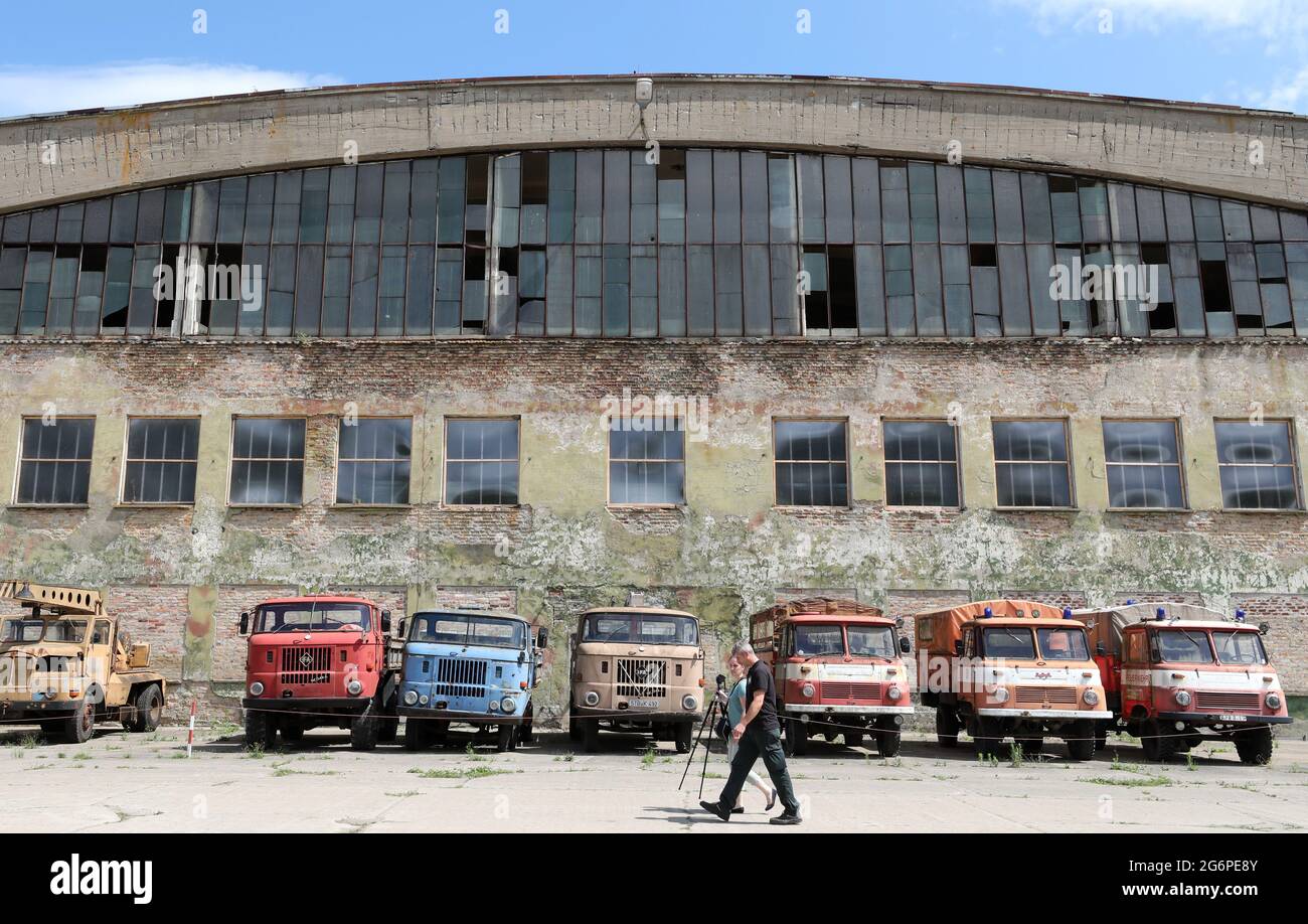 06 July 2021, Mecklenburg-Western Pomerania, Ribnitz-Damgarten: Former GDR trucks of the type 'Robur' and 'W50' stand in front of an exhibition hall in the Pütnitz Technology Museum. The museum is located on a former military airfield, which was built in 1935 and used by Russian troops until 1994. In three exhibition halls - former airplane hangars - 'technology of the former Eastern Bloc' is presented, in the open-air ground you can take part in driving activities with military vehicles and buses, among others. The Association of Friends and Sponsors of the Technical Museum will receive a gra Stock Photo