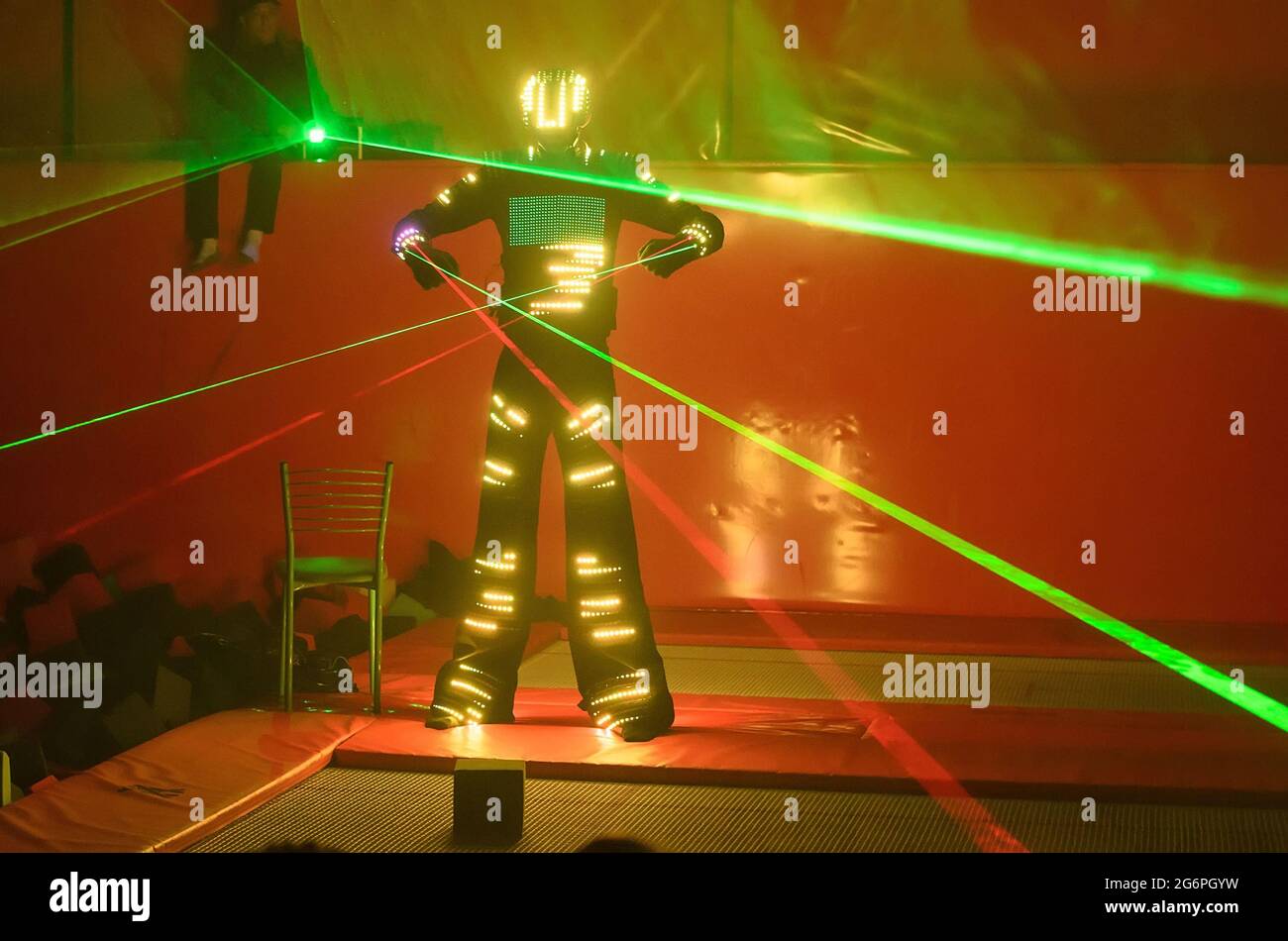 One dancer in a colored LED suit dances with a laser in his hands Stock Photo