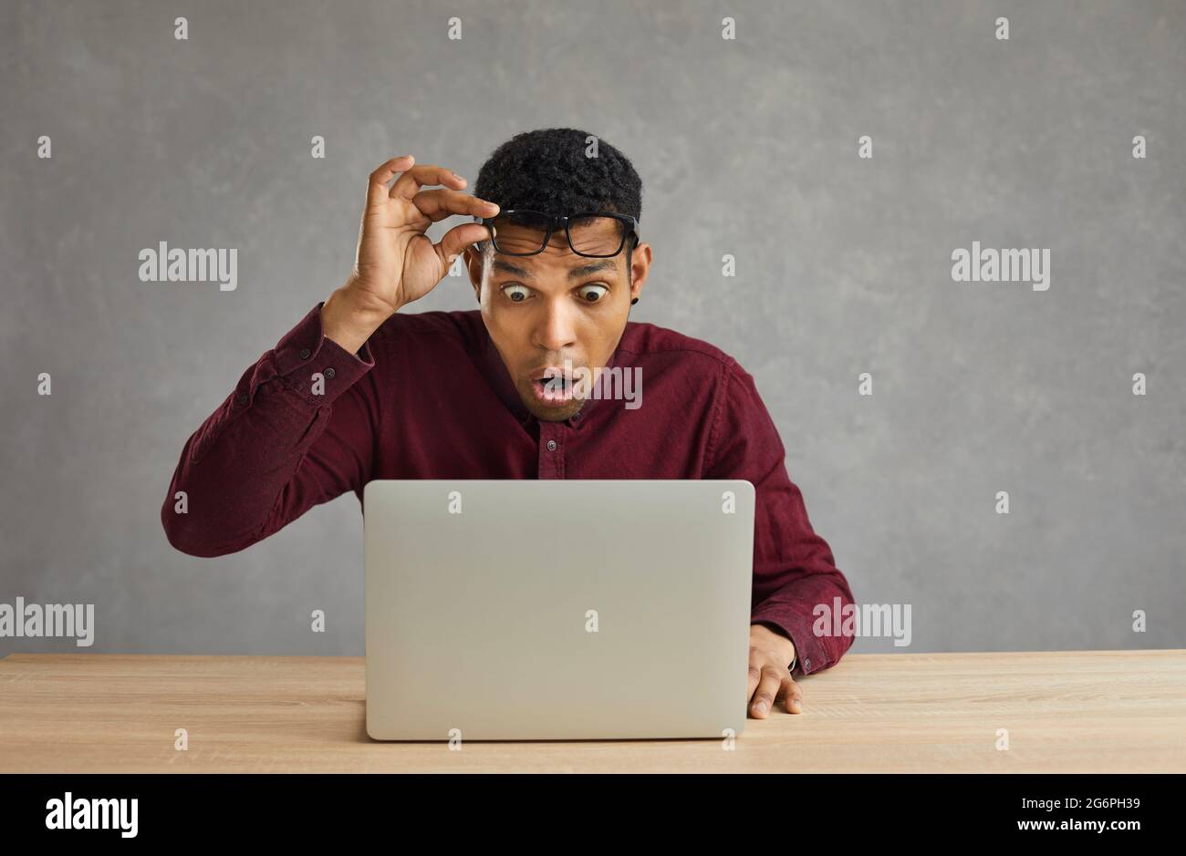 Shocked man take off eyeglasses looking with amazement face expression on laptop Stock Photo