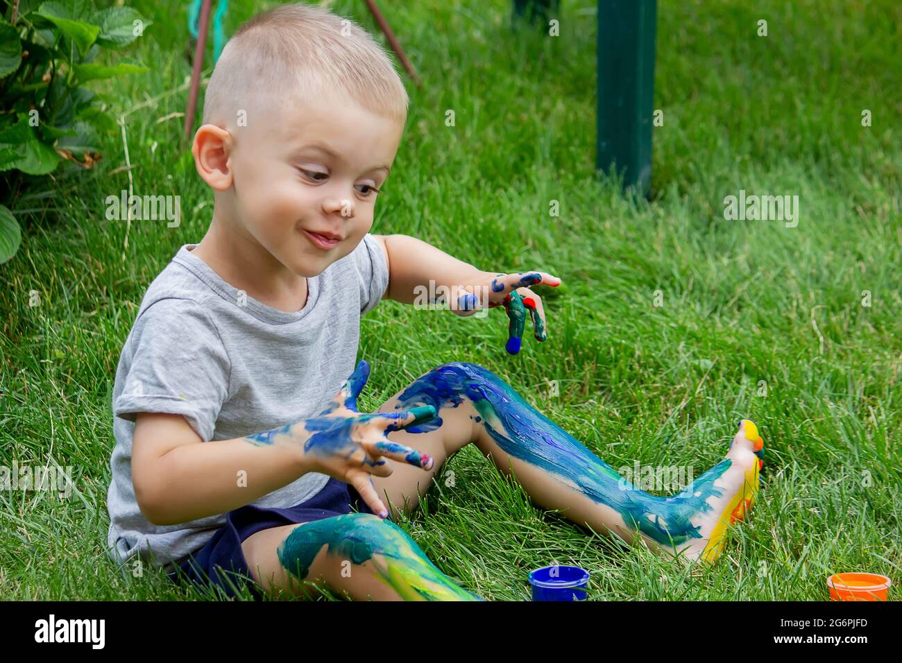 The child draws a pattern on the leg. A funny drawing with bright colors on the body. Selective focus Stock Photo