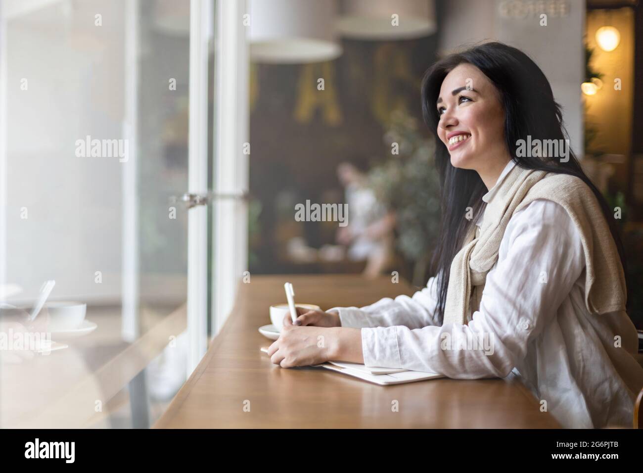 Closeup female hands making paper notes in notepad use pen table cafeteria writing diary, planning Stock Photo