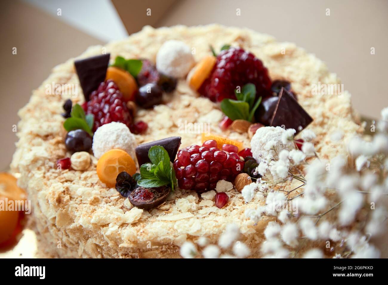 Birthday cake decorated with fruit, pomegranate seeds, chocolate and grapes. Happy holidays and Happy Birthday concept. Top view. High quality photo Stock Photo