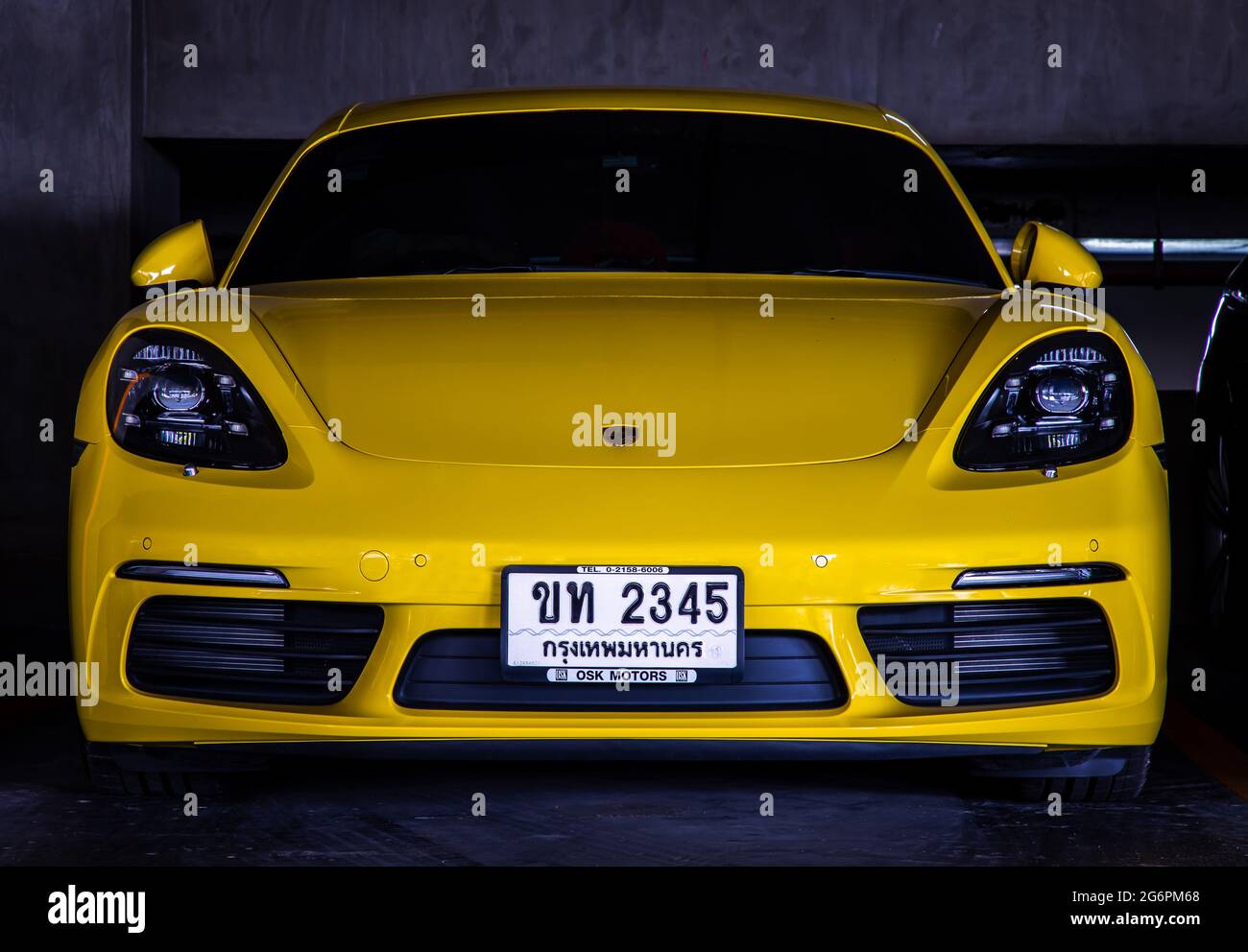 Bangkok, Thailand - 30 Jun 2021 : Front view shot of Yellow porsche sports car parked in the parking lot. Selective focus. Stock Photo
