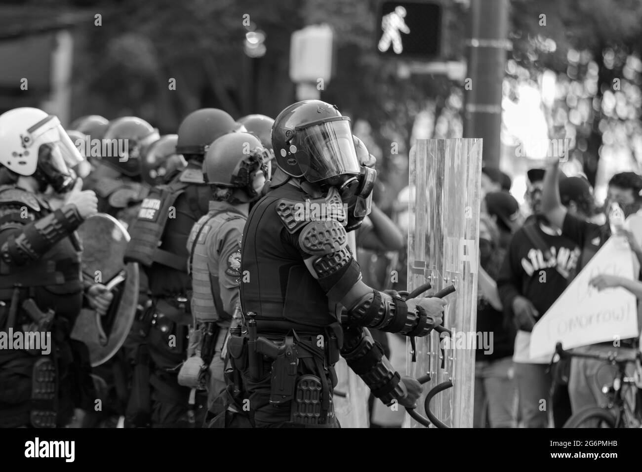 Police in riot gear confronting protesters. Stock Photo