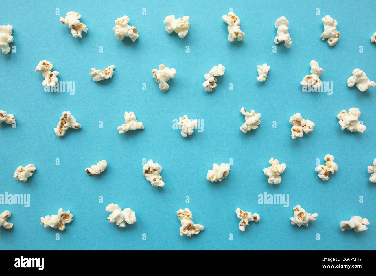Popcorn scattered on blue background. Popcorn pattern. top view. Stock Photo