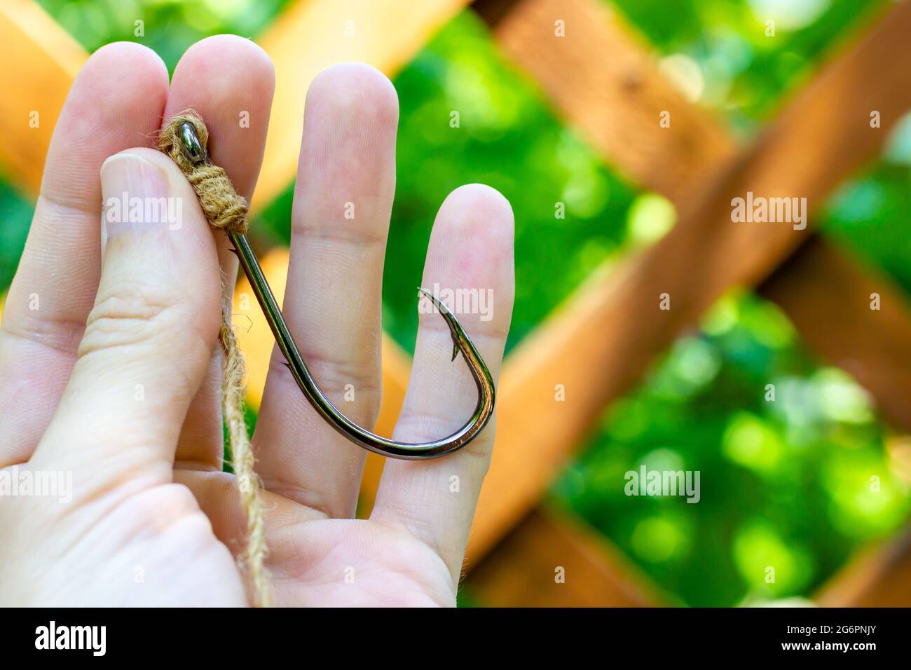 https://c8.alamy.com/comp/2G6PNJY/a-human-hand-holds-a-large-fishing-hook-hook-for-large-fish-2G6PNJY.jpg