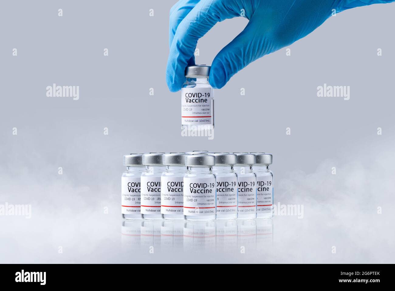 Hand holding frozen cold Vaccine vials for Covid-19 vaccine in laboratory. Group of Coronavirus vaccine bottles. Stock Photo