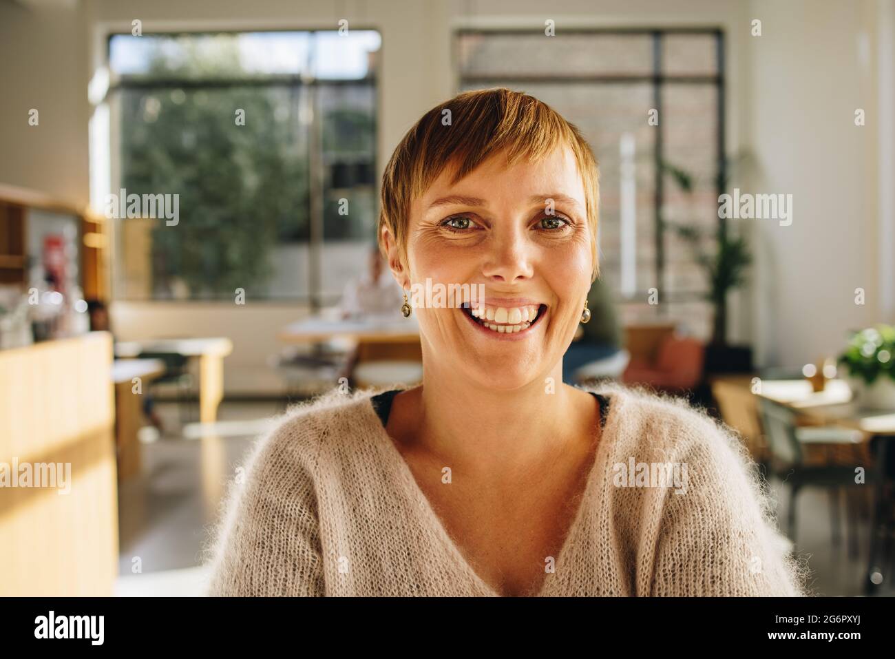 businesswoman in co-working space and smiling. Close-up of a cheerful female executive in office. Stock Photo