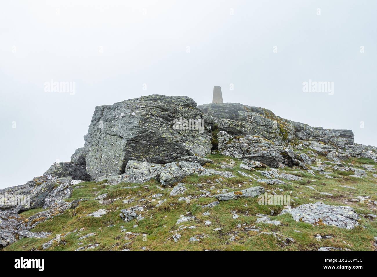 The summit trig point of the Munro mountain of Ben More near Crianlarich, Scotland, seen on a misty day with low visibility Stock Photo