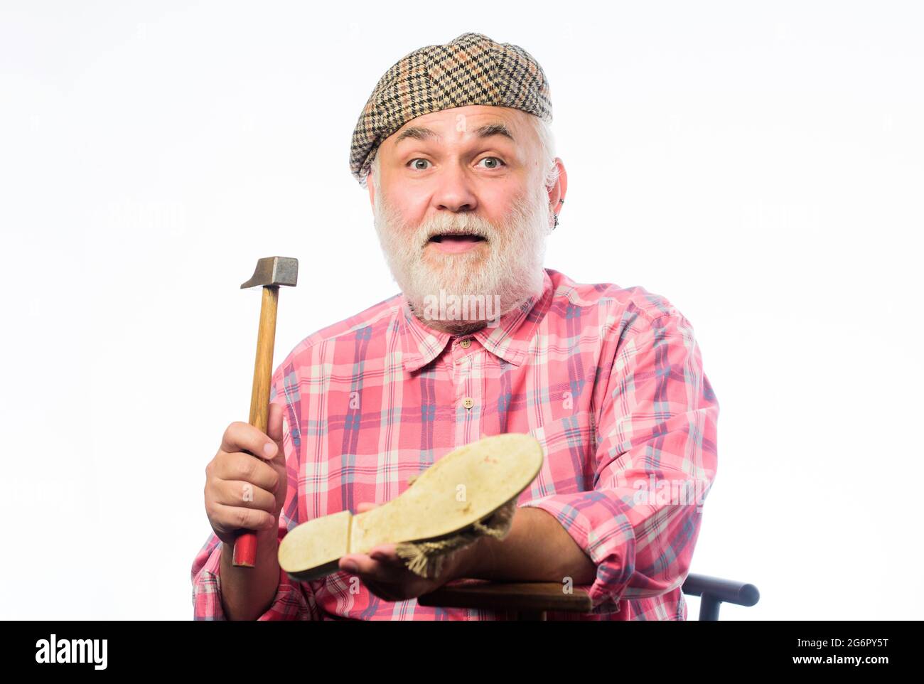 Shoe repair shop. Senior master with hammer repairing shoe. Handmade concept. Designing shoe