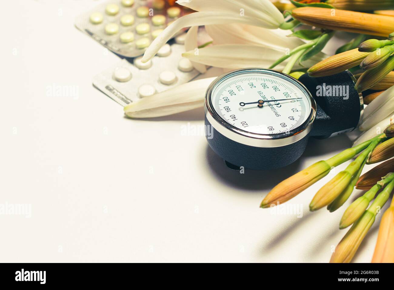 Sphygmomanometer for measuring blood pressure and pills. Hypertension day, photo for cardiology and heart disease with place for text on white. Stock Photo
