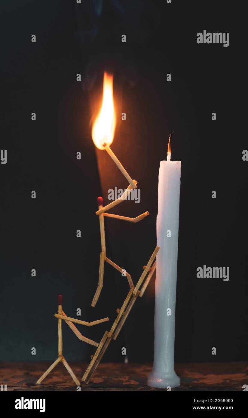 Matchsticks in form of a man lighting a candle, matchstick man lighting