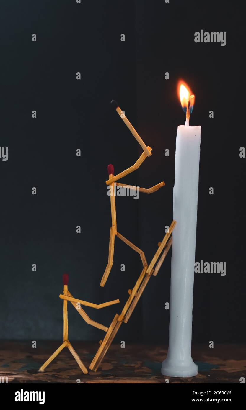 Matchsticks in form of a man lighting a candle, matchstick man lighting