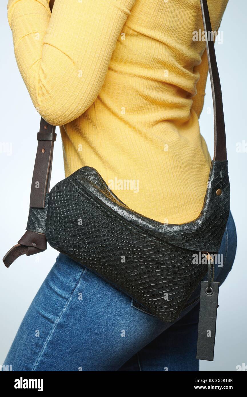 Small black leather bag on woman waist isolated close up view Stock Photo