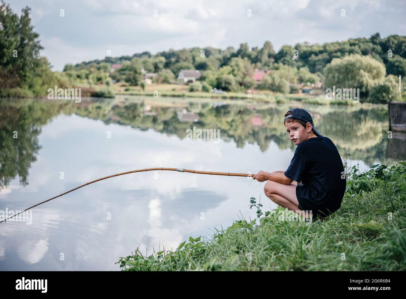 boy holding fishing reel and rodreel Boy child kid with rod reel hi-res stock photography and images