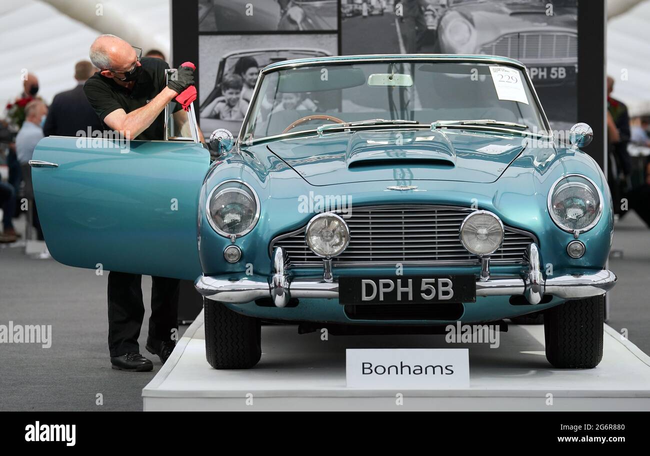 Chris Bailey, car presentation leader at Bonhams, cleans a 1964 Aston Martin DB5 convertible on display in the Bonhams Saleroom at the Goodwood Estate, Chichester, West Sussex, which was previously owned by Princess Margaret and Lord Snowdon, and actor Peter Sellers, and is estimated to fetch £1.3-1.5 million in the Bonhams Festival of Speed Sale on Friday. Picture date: Thursday July 8, 2021. Stock Photo