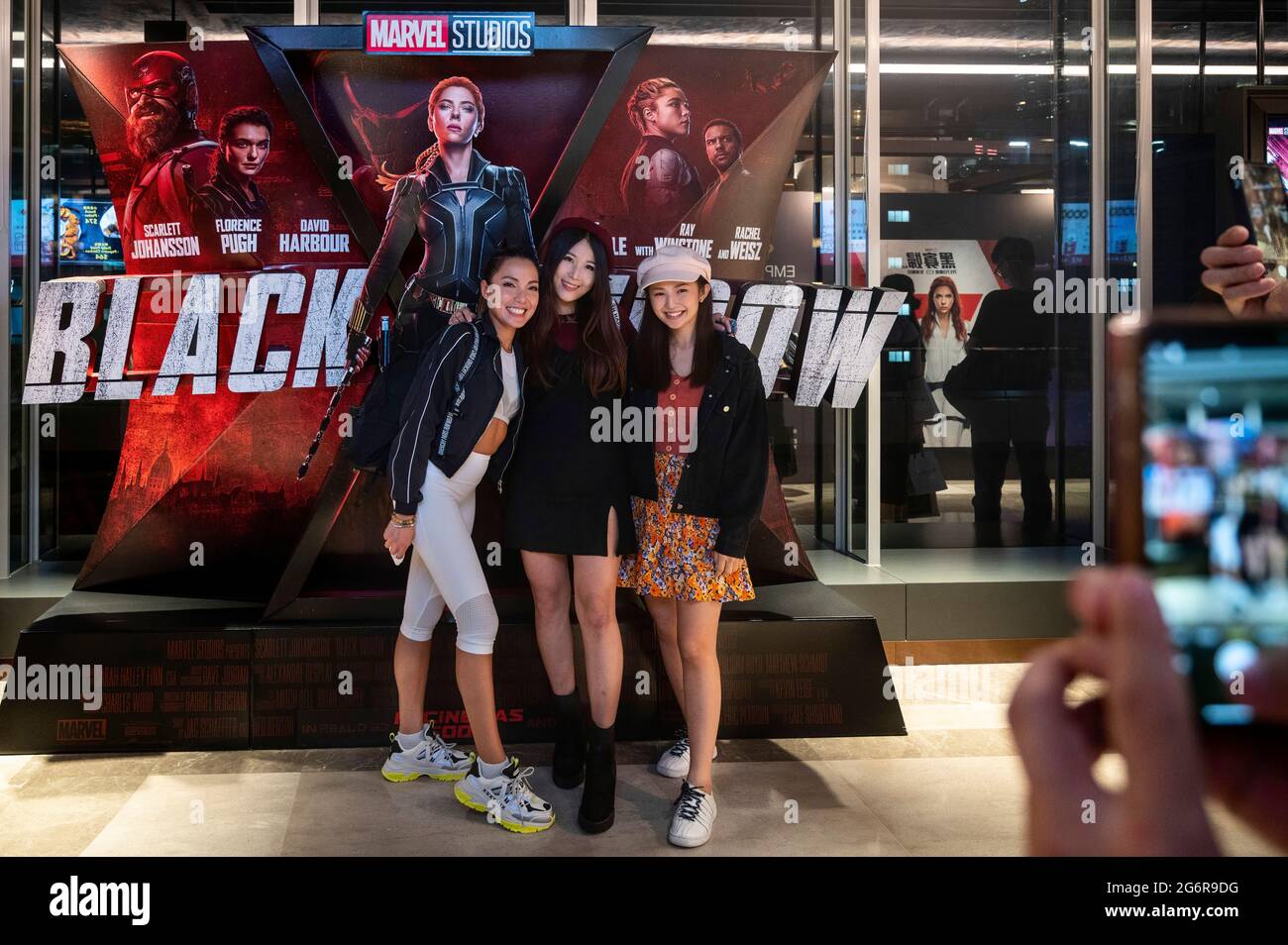Hong Kong, China. 07th July, 2021. Spectators pose in front of Disney's and Marvel Studios movie banner for the screening of Black Widow film, played by Scarlett Johansson, at a movie theater in Hong Kong. Credit: SOPA Images Limited/Alamy Live News Stock Photo