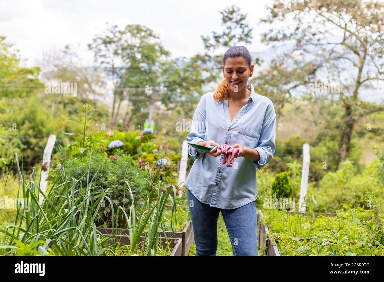 woman holding gardening tools in her hands in her vegetable garden Stock Photo