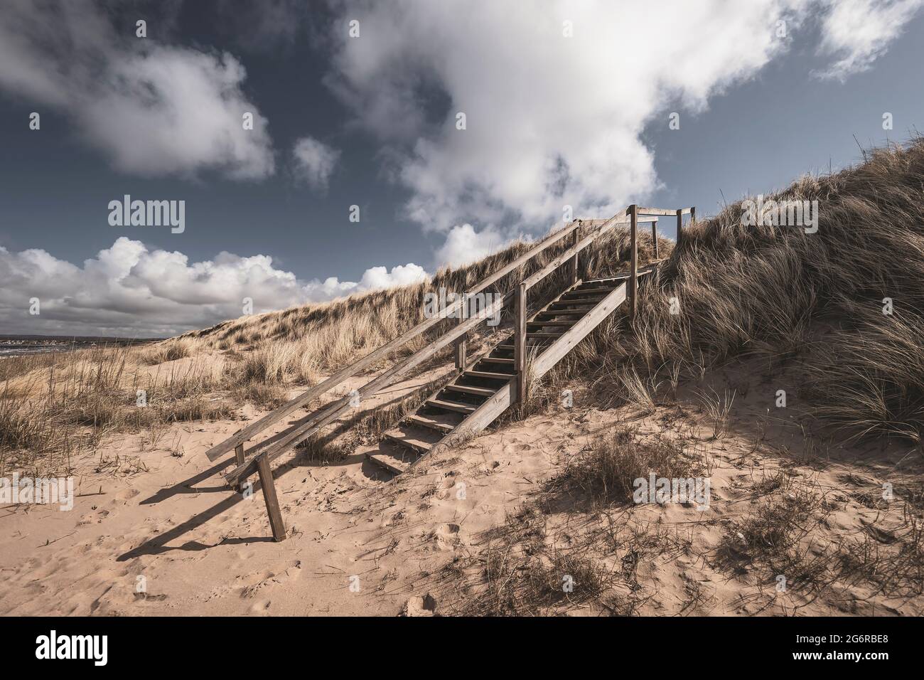 Wooden stairs leading to a sandy beach. Angelholm, Sweden. Stock Photo