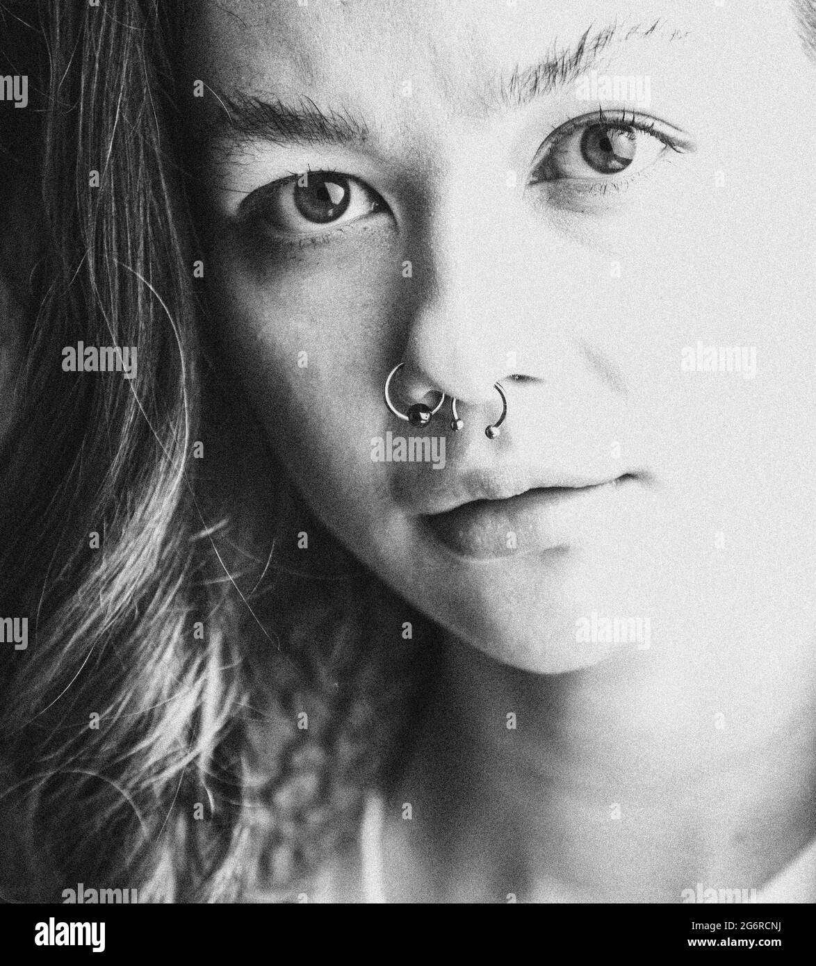 A close-up portrait of a young woman looking serious and looking at the camera. Stock Photo