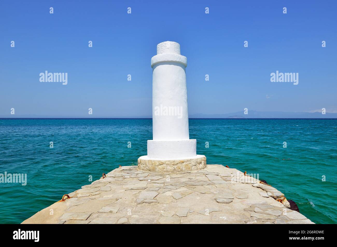 Lighthouse on the end of a pier in the Aegean Sea. Pefkohori, Kassandra, Chalkidiki, Greece Stock Photo