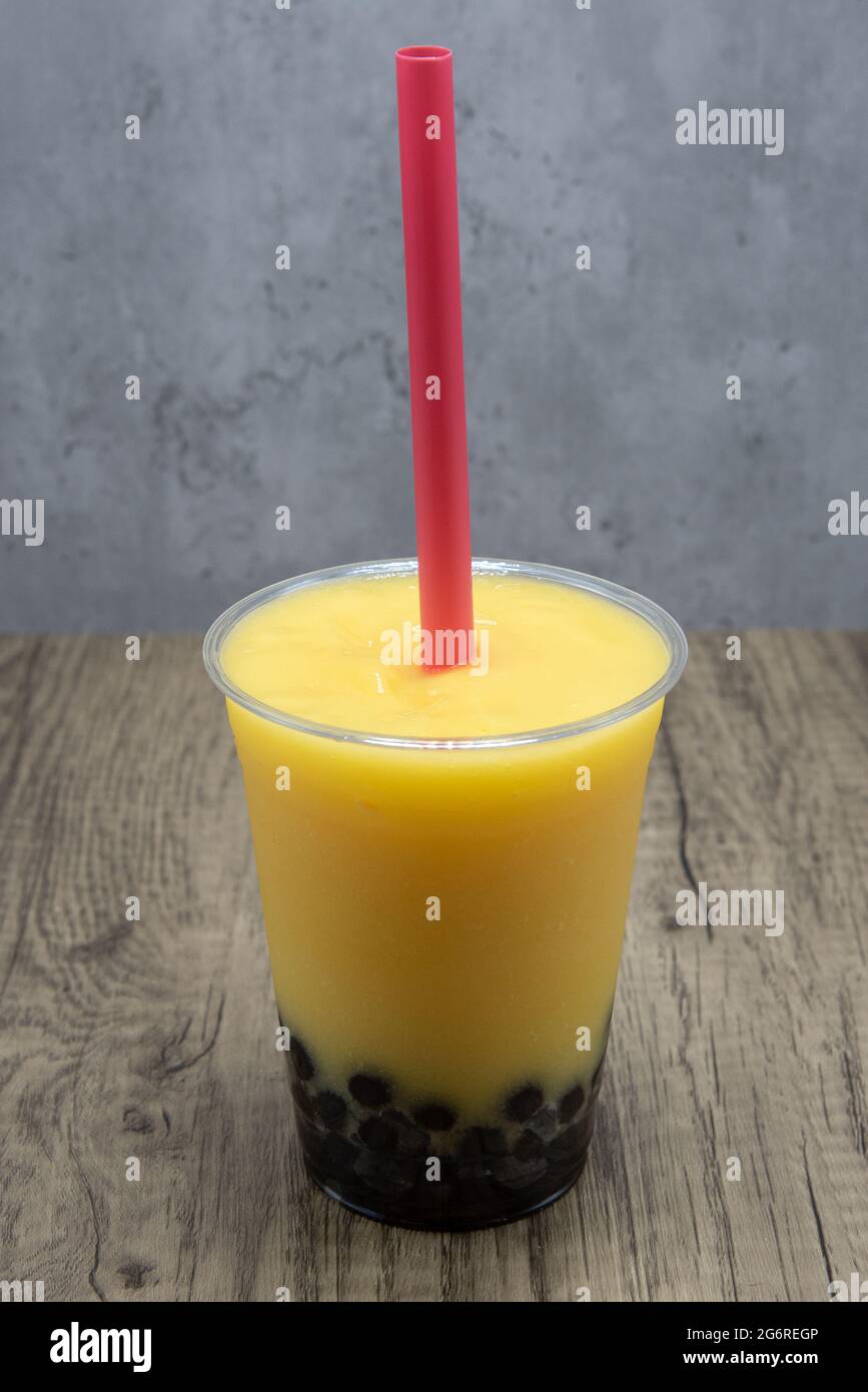 Mango flavored smoothie with sweet tapioca boba balls at the bottom of