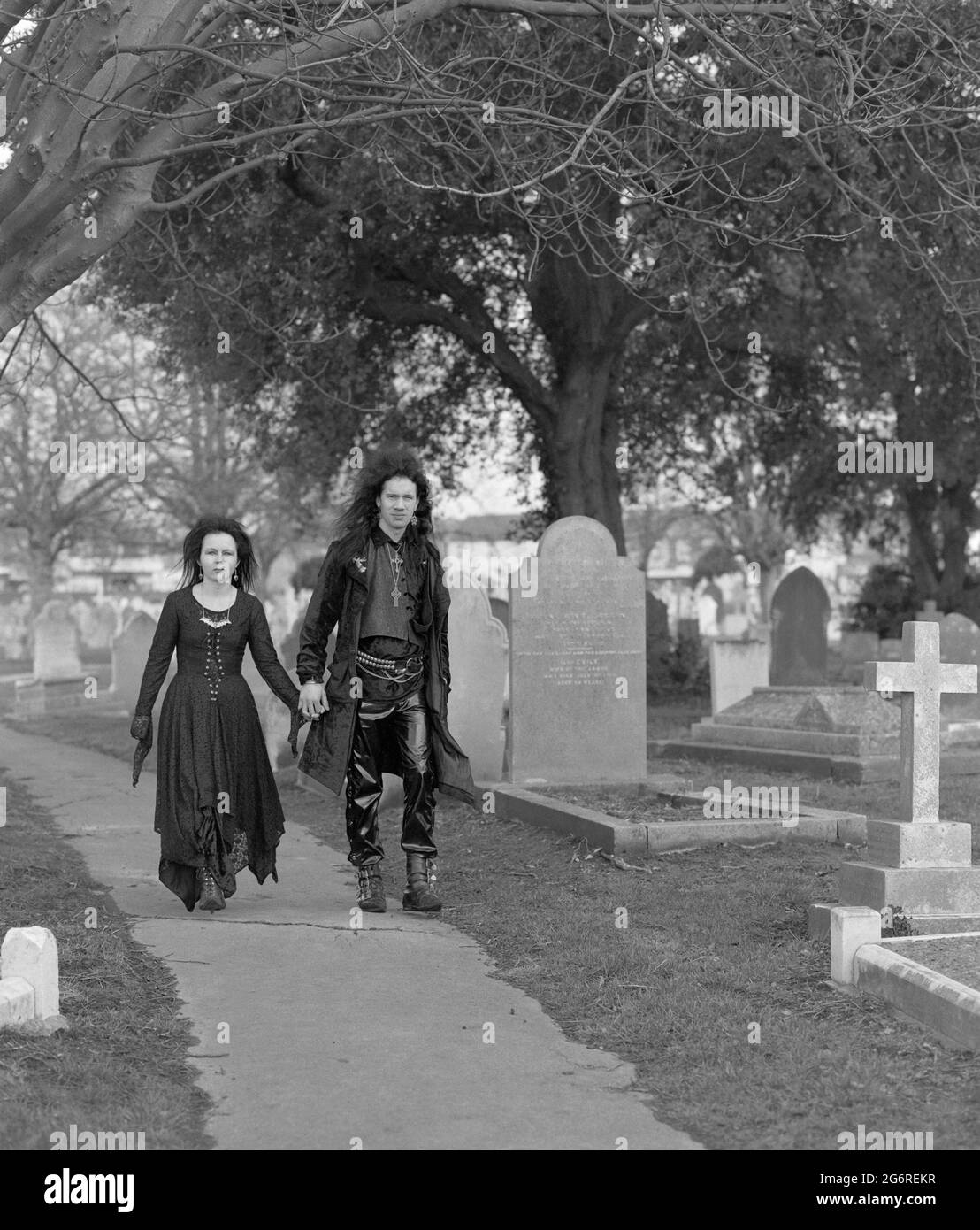 man and woman goths couple walking in churchyard1990s england uk Stock Photo