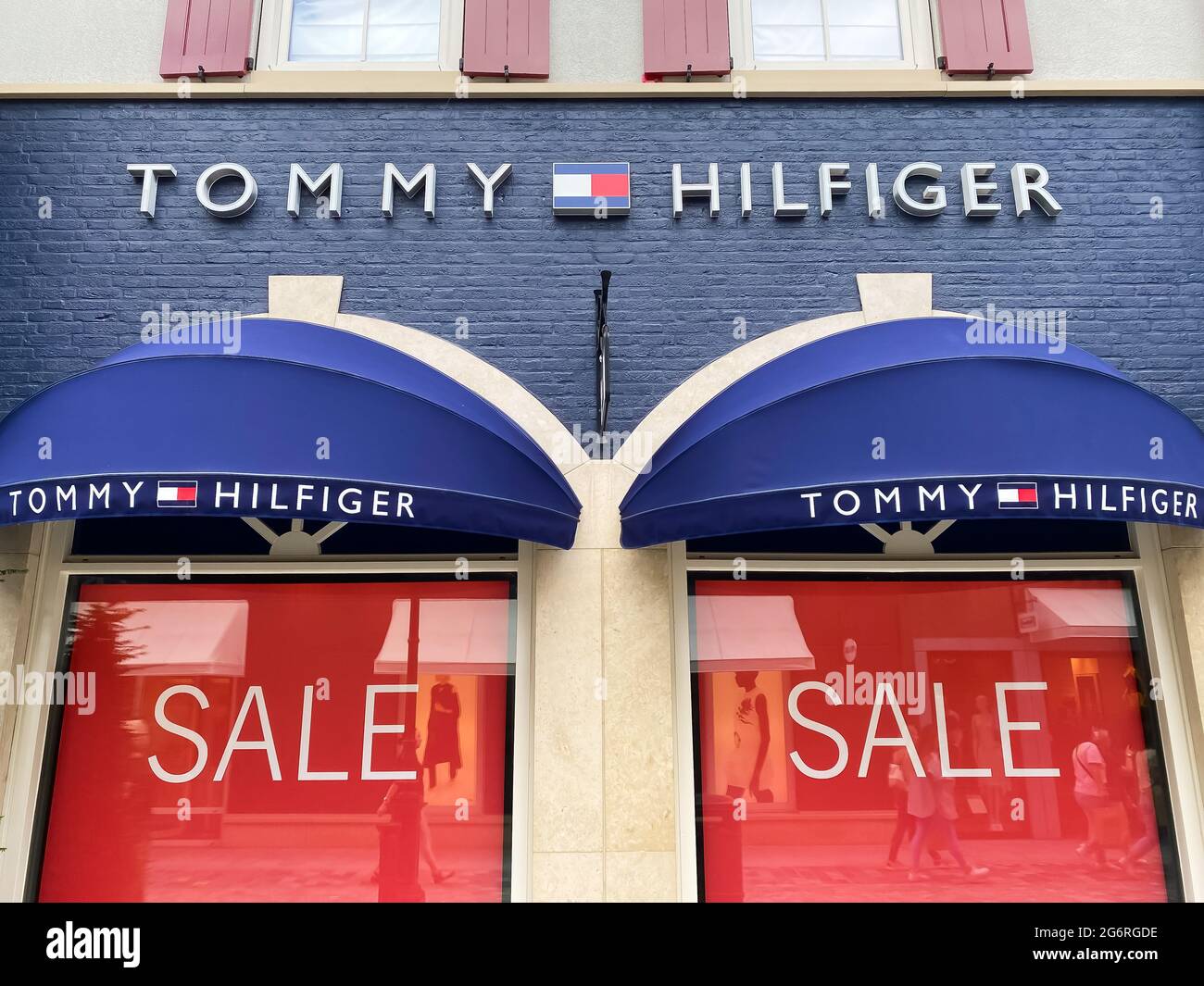 Roermond, Netherlands - July 1. 2021: View on store facade with logo  lettering of tommy hilfiger and red sale signs in window (focus on center  of uppe Stock Photo - Alamy