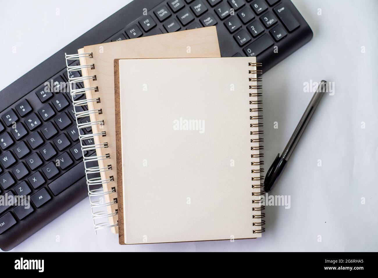 Two Plain Lined Spiral Notebooks With Pen And Keyboard On Table. Simple